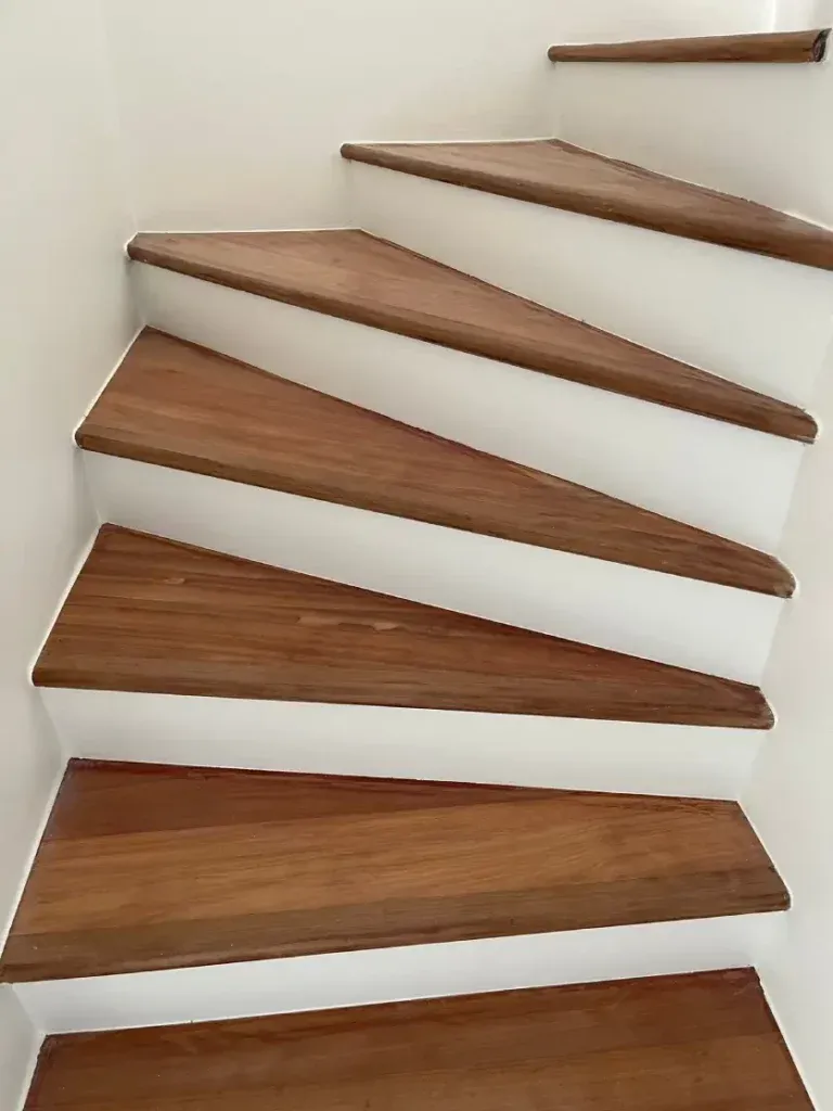 Escalier rénové à Cernay avec marches en bois massif brun, contremarches blanches et partie tournante